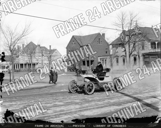 Automobile on town street, vintage black and white photograph